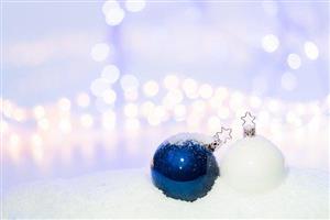 Blue and white bauble ornaments on a bed of snow.